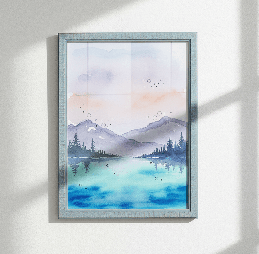 Blue-washed wood picture frame hangs on white wall displaying watercolor painting of mountains and lake in soft pastel hues