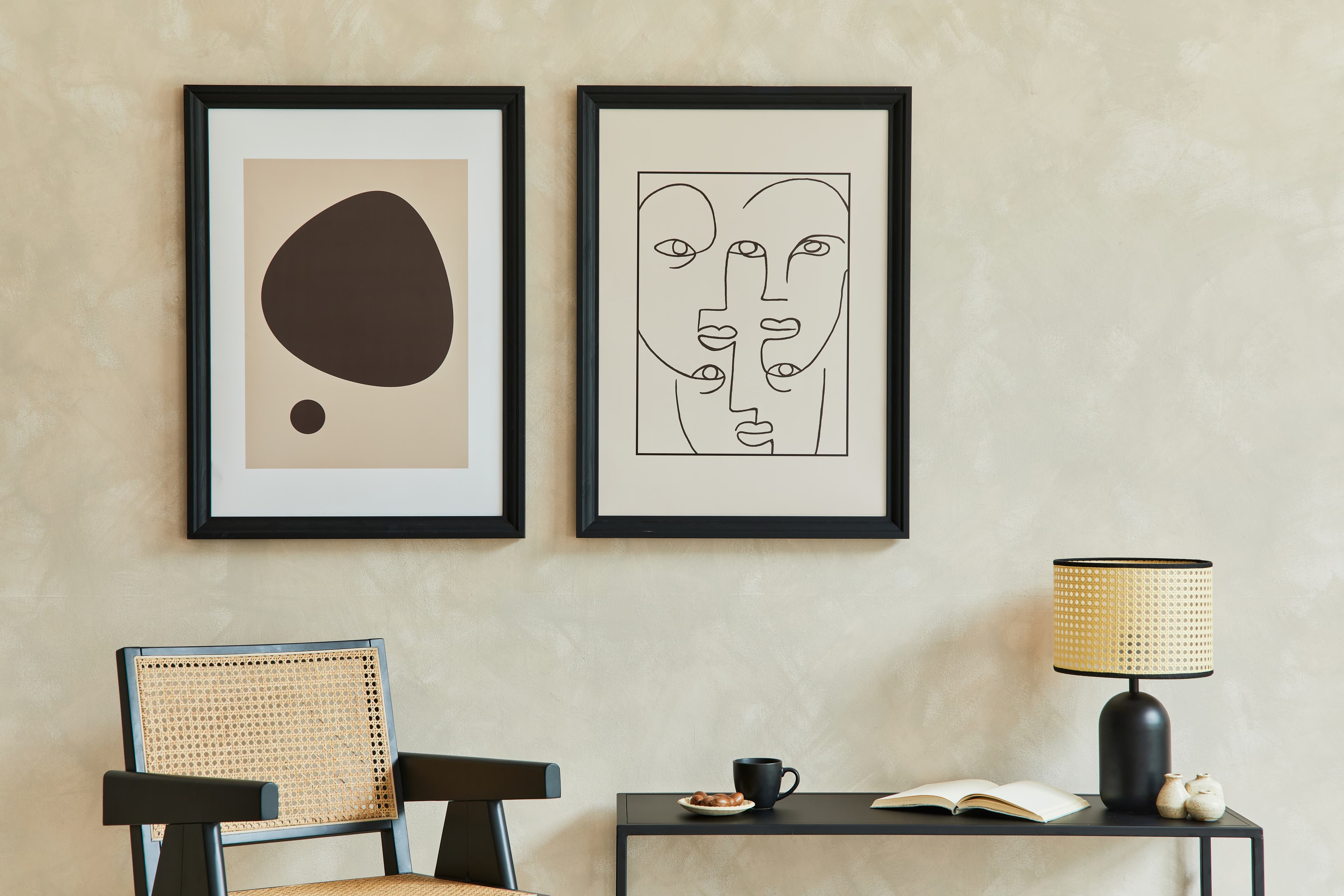 Modern Black picture frames in minimalist living room setting displaying abstract art and modern line drawings with white matting creating sophisticated contemporary gallery wall